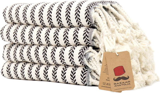 Set of four black Arpa Turkish cotton hand towels with tasseled ends.