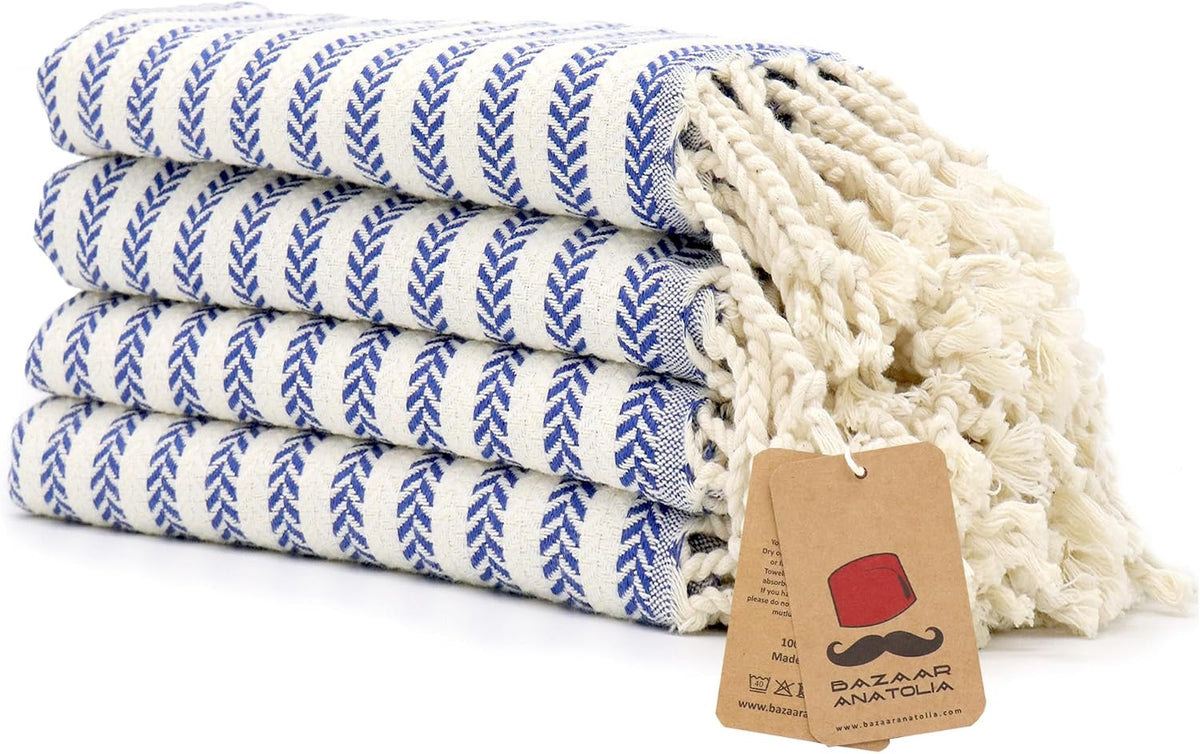 Set of four royal blue Arpa Turkish cotton hand towels with tasseled ends.