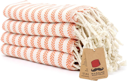 Set of four orange Arpa Turkish cotton hand towels with tasseled ends.