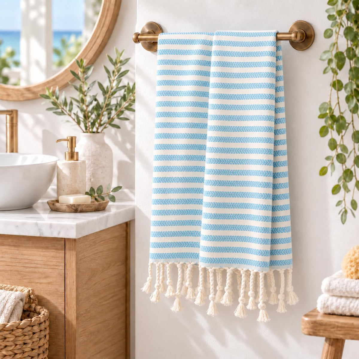 Turquoise striped Arpa cotton hand towel hanging from a bathroom rail beside a basin and mirror.