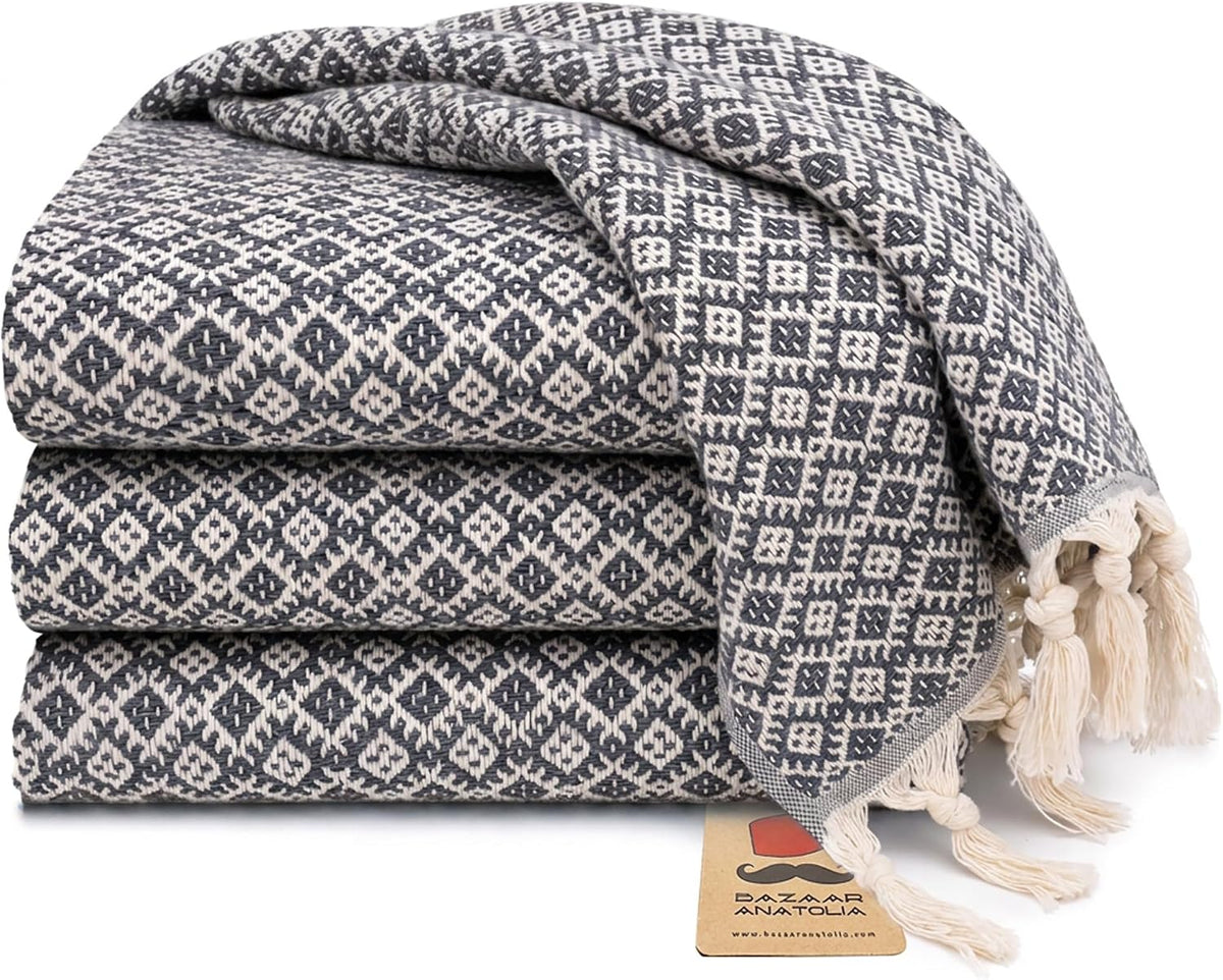 Set of four dark gray Ethnic Turkish cotton hand towels with tasseled ends.