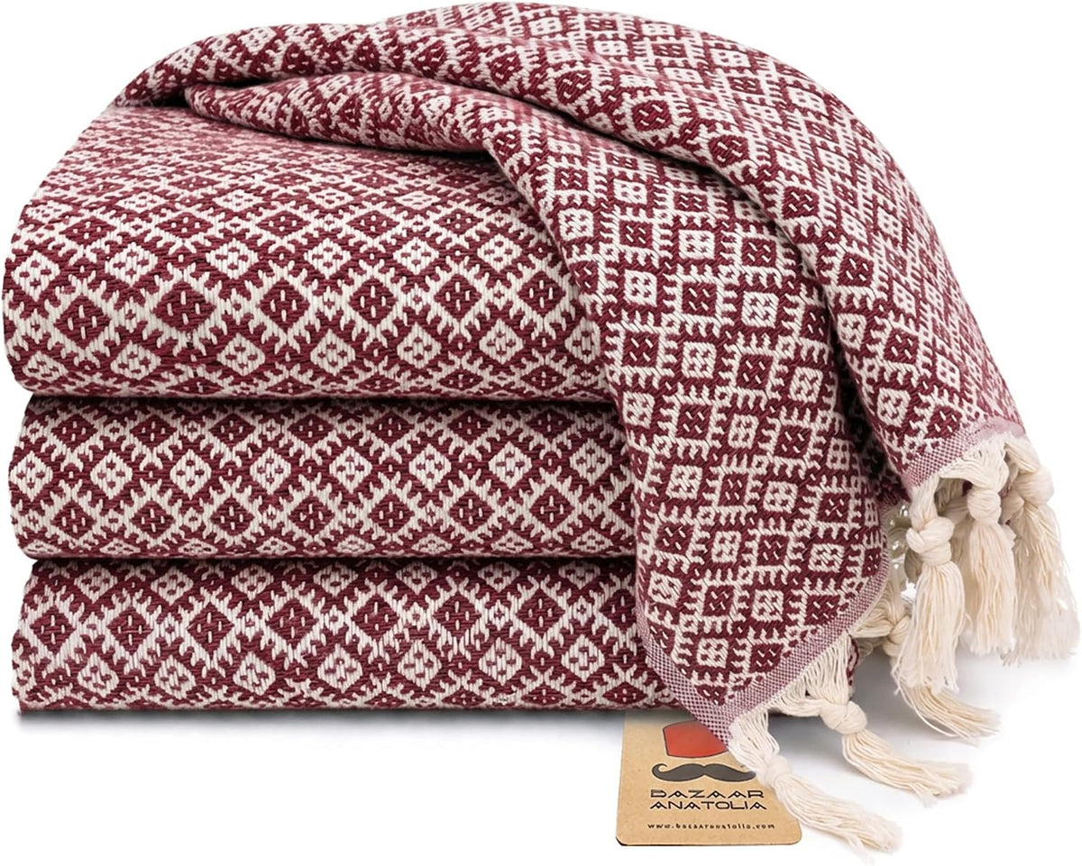 Set of four maroon Ethnic Turkish cotton hand towels with tasseled ends.