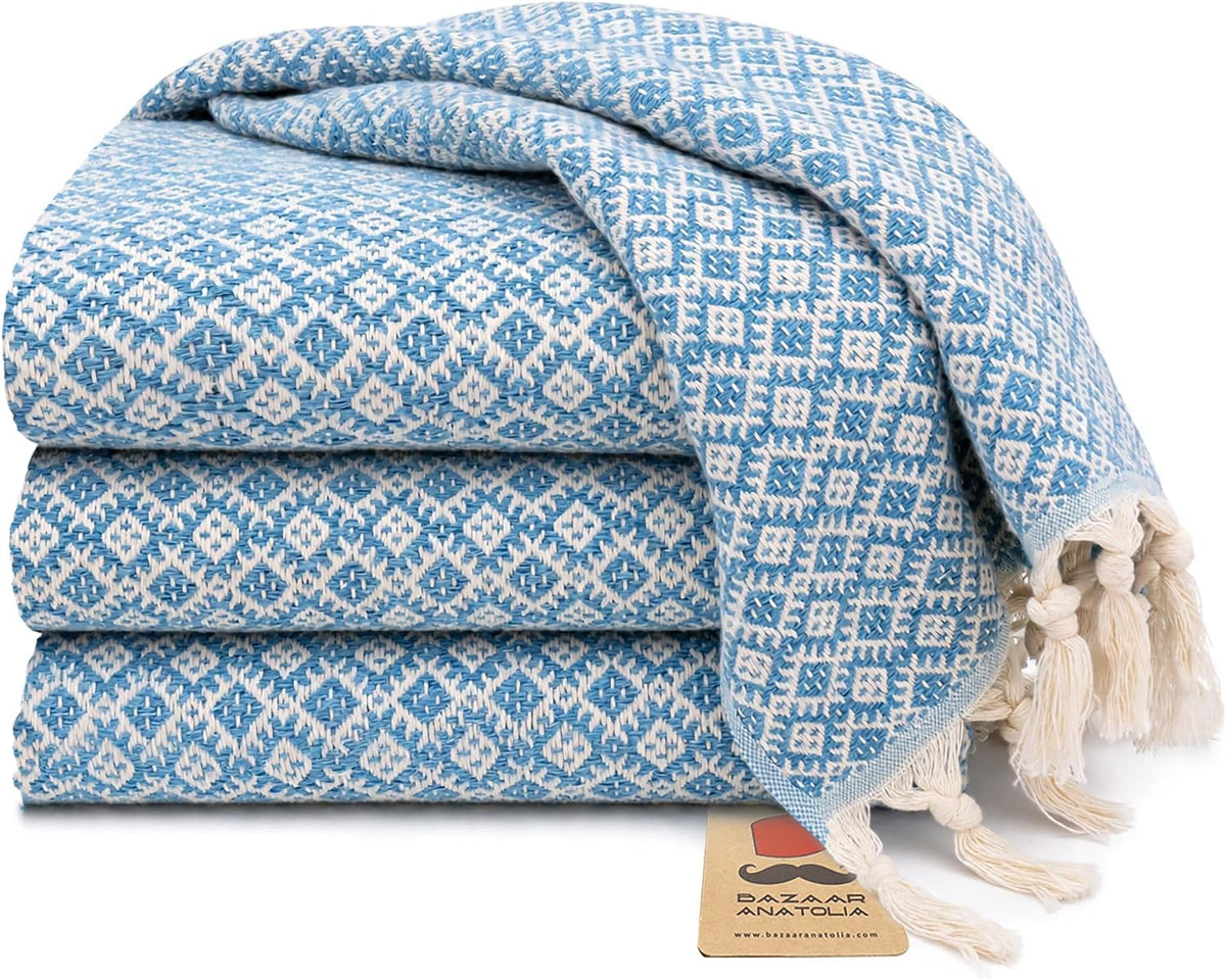 Set of four turquoise Ethnic Turkish cotton hand towels with tasseled ends.